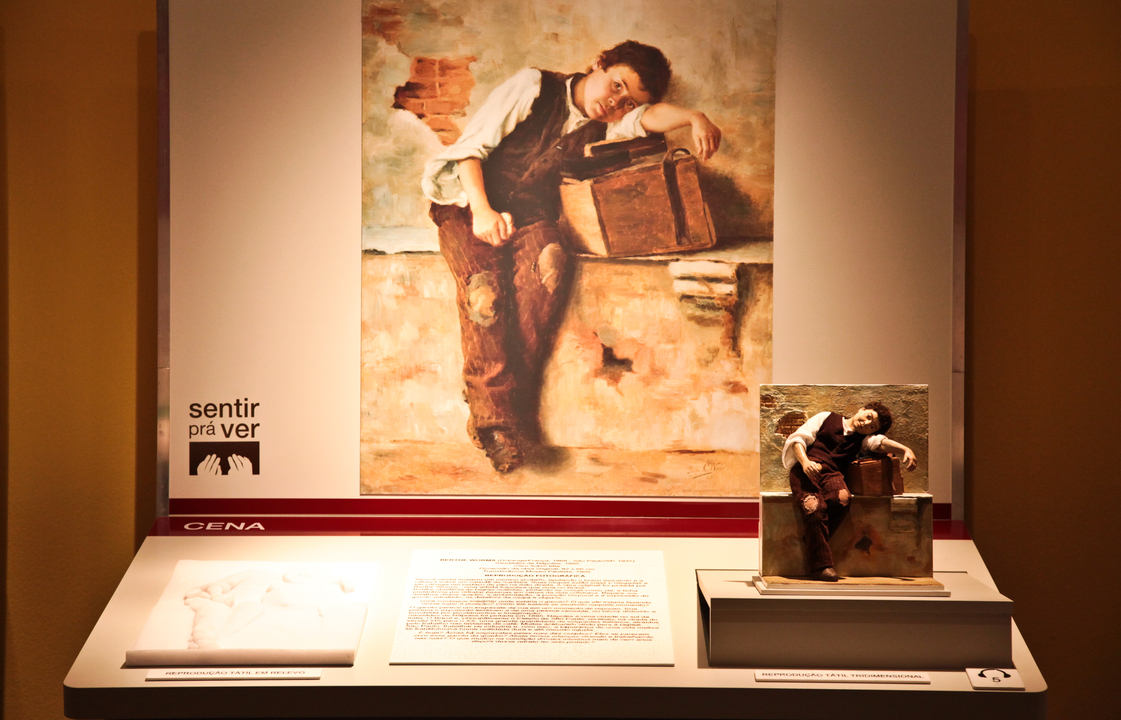 Bancada acessível da exposição com o tema Cena, contendo reprodução fotografica, maquete e relevo tátil e texto em dupla leitura da obra de Berth Worms, intitulada Saudades de Nápoles, 1895.
