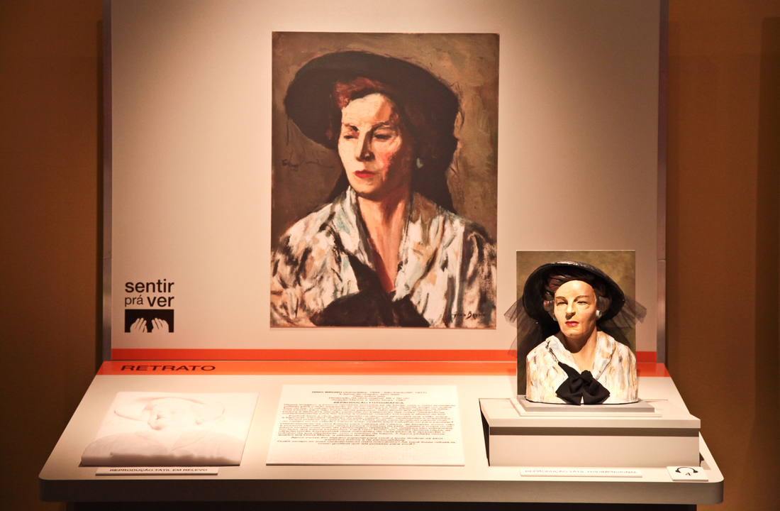 bancada acessível da exposição, tema retrato, contendo reprodução fotografica, maquete e relevo tátil e texto em dupla leitura da obra de Gino Bruno, intitulada A dama de chapéu, sem data.