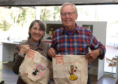 Casal de idosos segurando suas sacolas com a produção de artes aplicadas.
